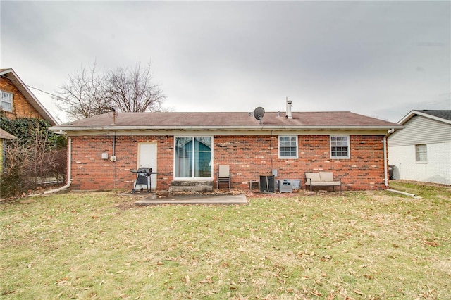 rear view of house featuring a yard, central AC, a patio, and brick siding