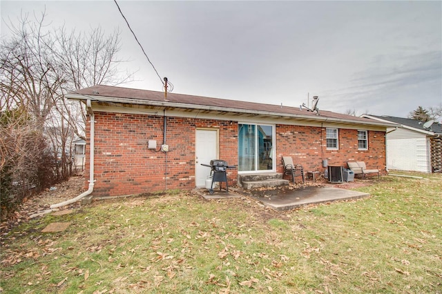 rear view of property with entry steps, a patio, central AC, brick siding, and a lawn