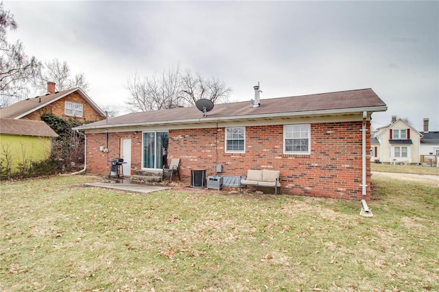 rear view of property with central AC, a patio, brick siding, and a lawn