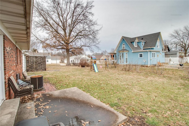 view of yard featuring a residential view, a patio area, a playground, and central air condition unit