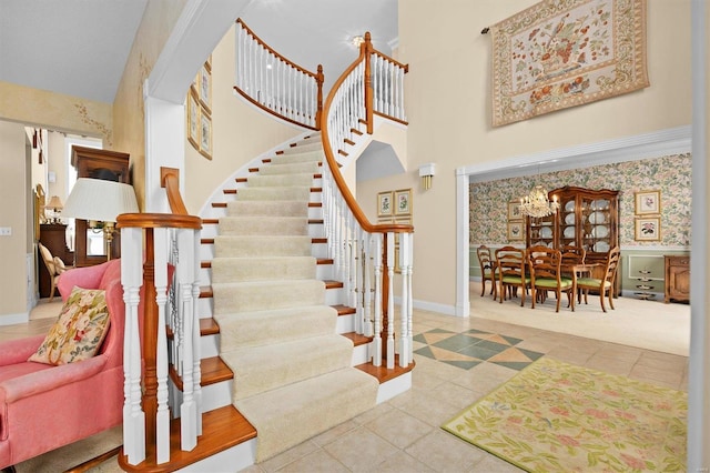 stairs with tile patterned flooring, baseboards, and a high ceiling