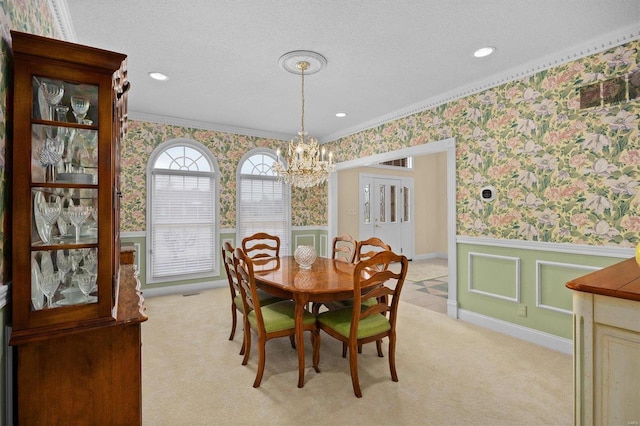 dining room with light carpet, wainscoting, and wallpapered walls