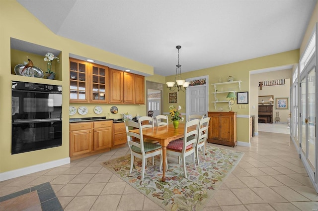 dining area with baseboards, an inviting chandelier, and light tile patterned floors