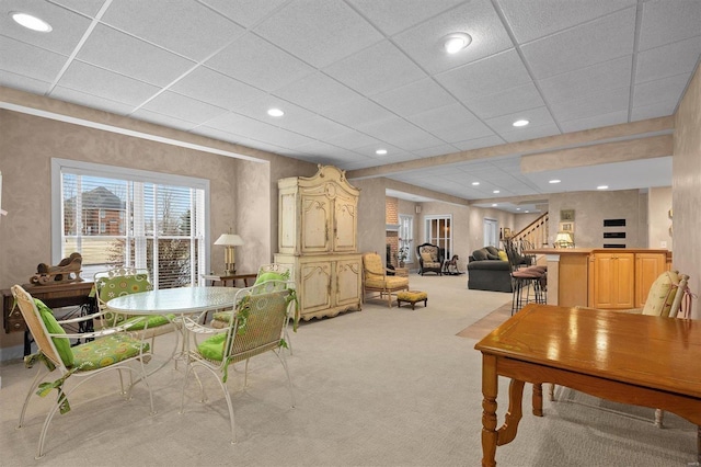 interior space with a paneled ceiling, light carpet, recessed lighting, and stairs