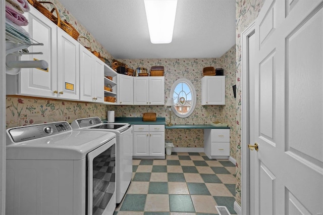 laundry area with wallpapered walls, dark floors, washer and dryer, and cabinet space