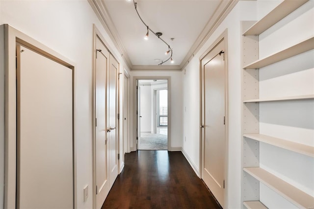 hall with dark wood-style floors, rail lighting, and crown molding