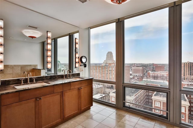 kitchen with a view of city, brown cabinetry, a sink, and a wall of windows