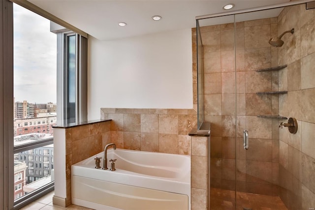 full bath with a city view, recessed lighting, a shower stall, a bath, and expansive windows