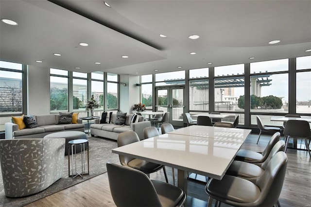 dining space with floor to ceiling windows, french doors, wood finished floors, and recessed lighting