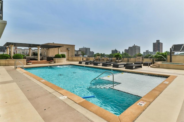 community pool with a view of city, a patio, and a hot tub