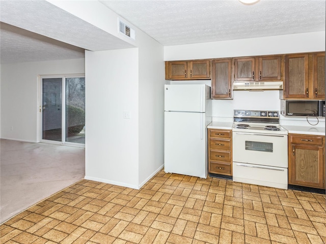 kitchen with white appliances and a textured ceiling