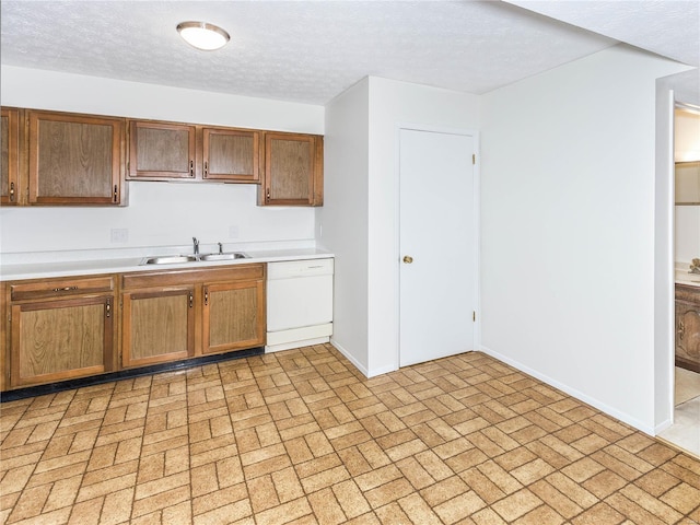 kitchen featuring sink, white dishwasher, and a textured ceiling