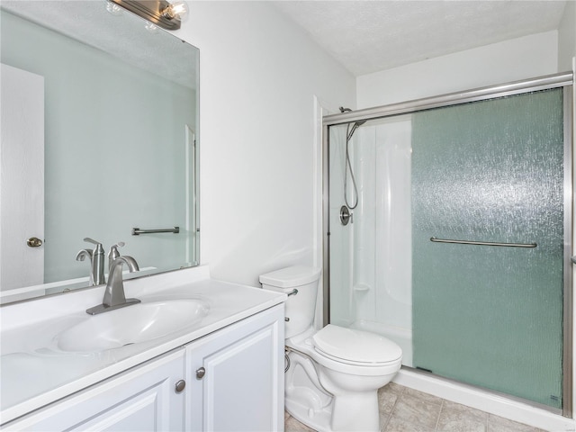 bathroom with toilet, a textured ceiling, an enclosed shower, tile patterned floors, and vanity