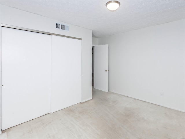 unfurnished bedroom with a textured ceiling and a closet