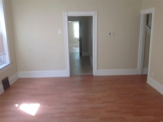 spare room featuring light wood-style flooring and baseboards