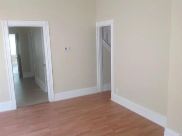 spare room featuring light wood-style flooring and baseboards