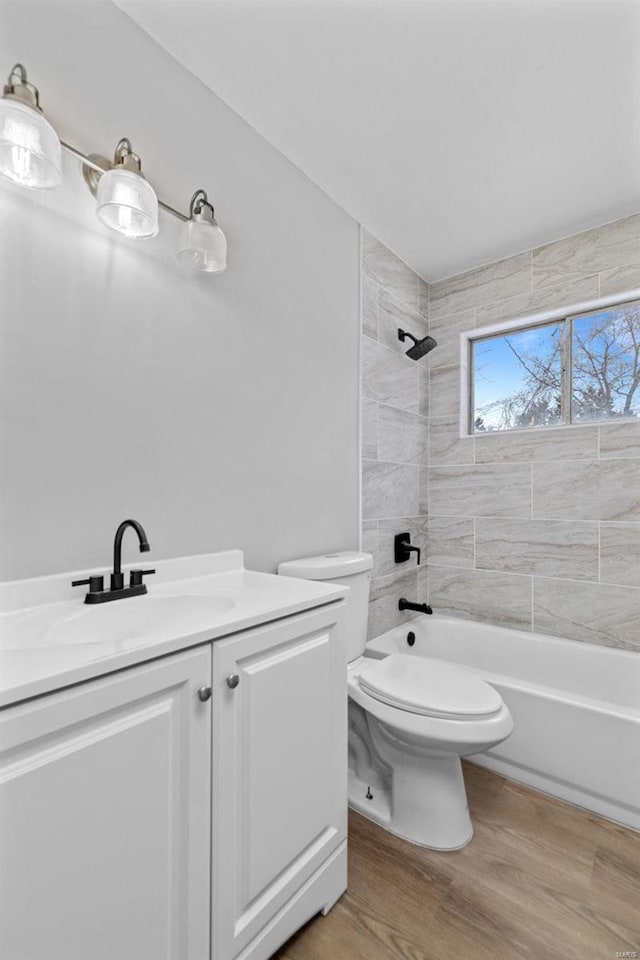 bathroom with toilet, shower / washtub combination, wood finished floors, and vanity