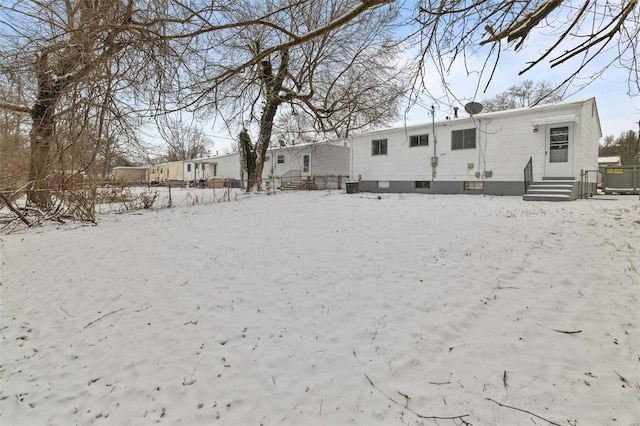 snow covered house with entry steps and fence