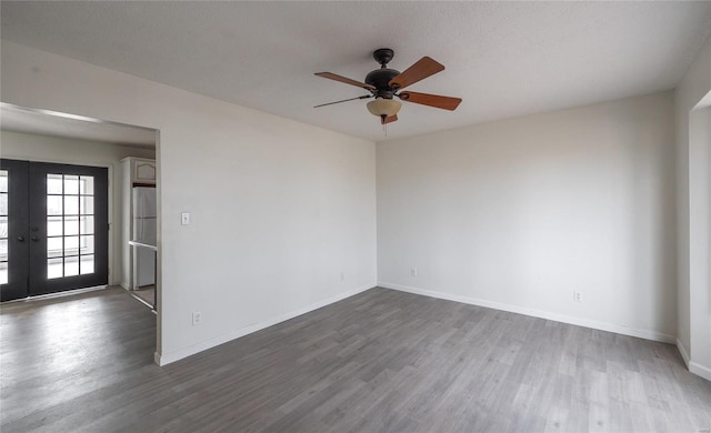 unfurnished room with baseboards, dark wood-style flooring, and french doors