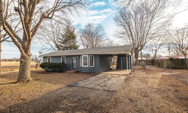 ranch-style home with driveway, fence, and a carport