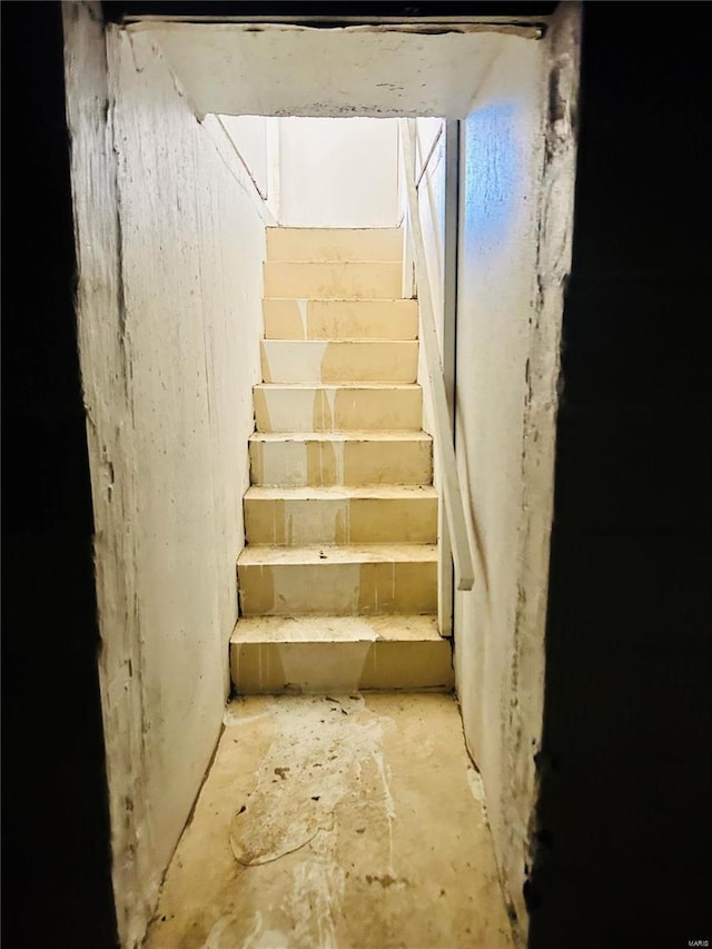 staircase featuring unfinished concrete floors