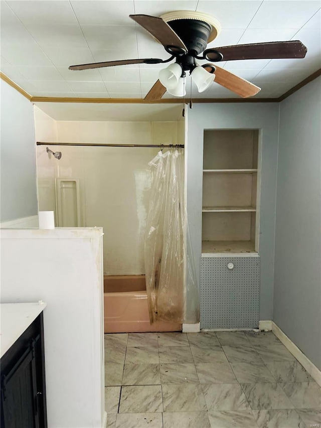 bathroom with built in shelves, baseboards, shower / tub combo with curtain, vanity, and a ceiling fan