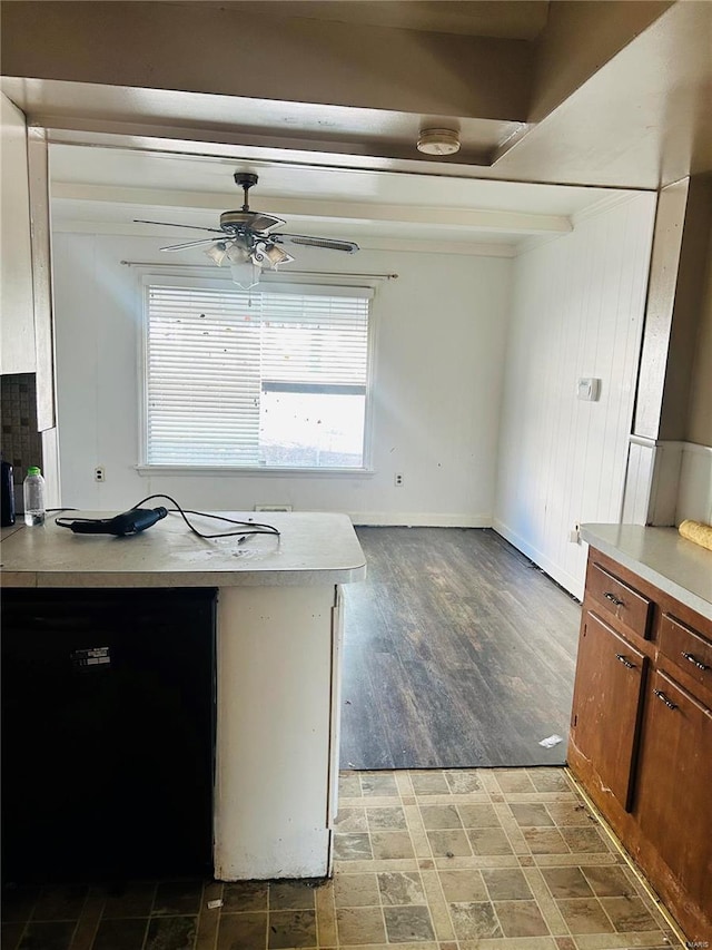 kitchen with brown cabinetry, ceiling fan, light countertops, and black dishwasher