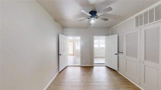 unfurnished bedroom with visible vents, ceiling fan, baseboards, and wood finished floors