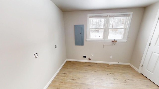 interior space with light wood-style flooring, electric panel, and baseboards