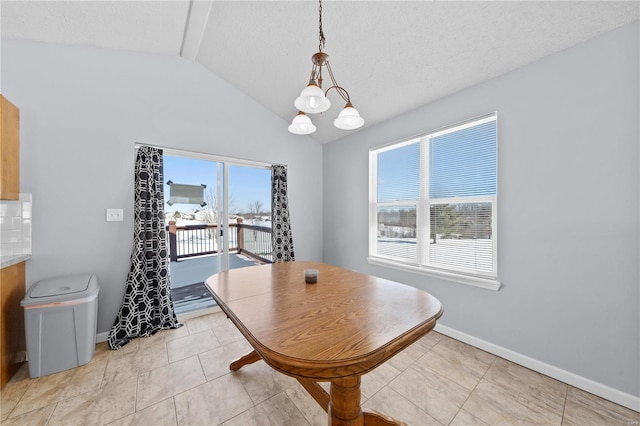 dining area with lofted ceiling, plenty of natural light, a chandelier, and baseboards