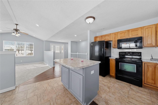 kitchen featuring light tile patterned flooring, a center island, open floor plan, decorative backsplash, and black appliances