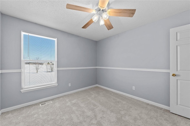 empty room featuring baseboards, visible vents, a textured ceiling, and light colored carpet