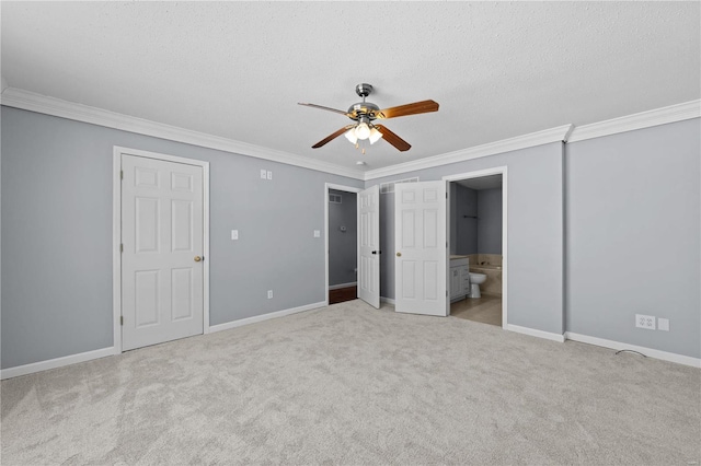 unfurnished bedroom with light colored carpet, crown molding, a textured ceiling, and baseboards