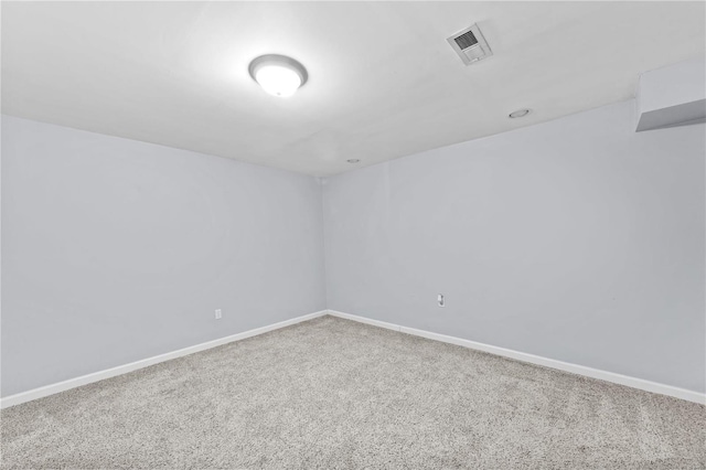 carpeted empty room featuring baseboards and visible vents