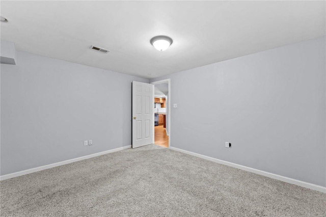 carpeted spare room with visible vents and baseboards