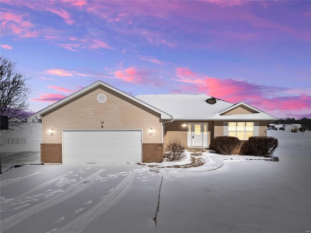 single story home featuring an attached garage and brick siding