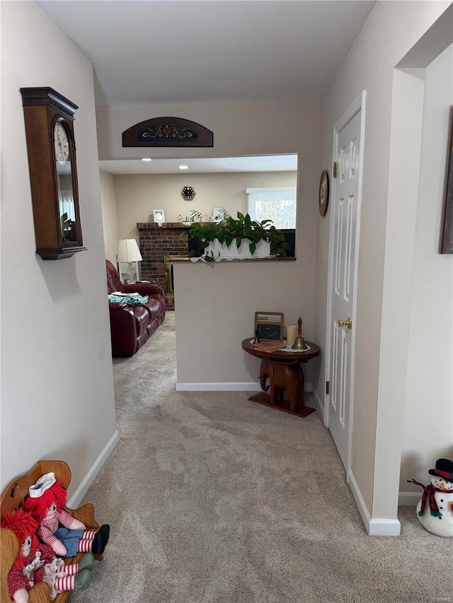 hallway featuring light carpet and baseboards