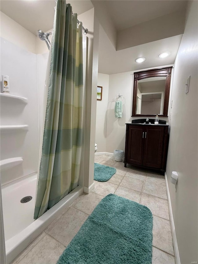 full bath with toilet, vanity, baseboards, tile patterned floors, and a stall shower