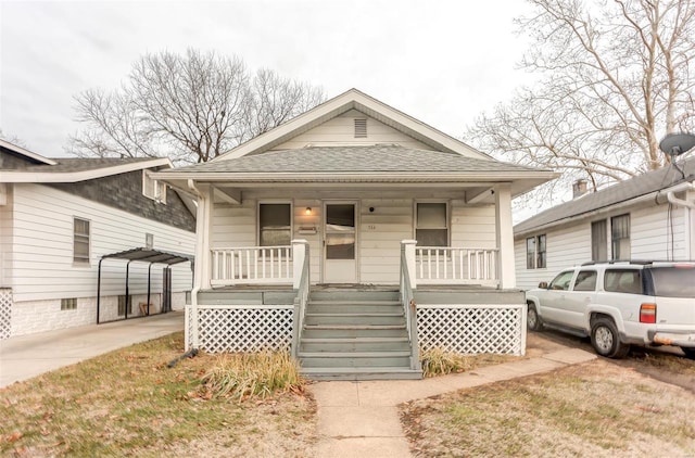 view of front of property with concrete driveway, a porch, and a shingled roof