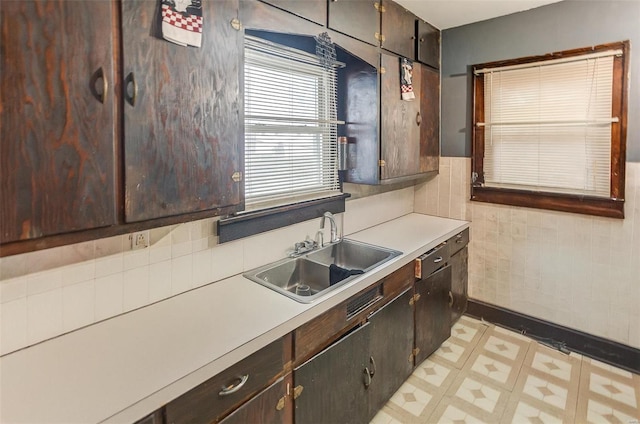 kitchen with light countertops, a sink, light floors, and dark brown cabinets