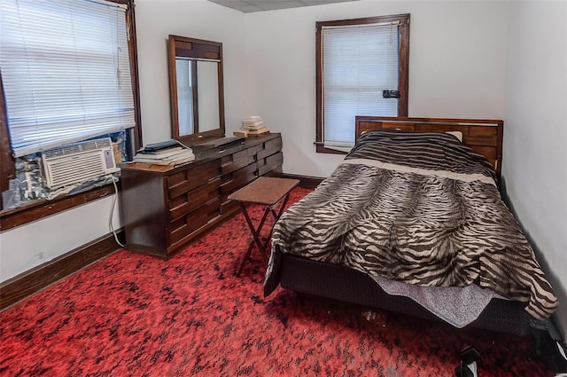 bedroom with baseboards, dark carpet, and cooling unit