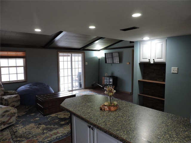 kitchen with dark countertops, open floor plan, white cabinetry, and visible vents