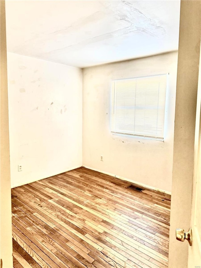 spare room with light wood-type flooring and visible vents