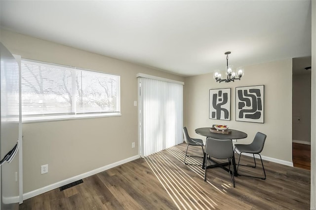 dining room with baseboards, visible vents, a chandelier, and dark wood-style flooring