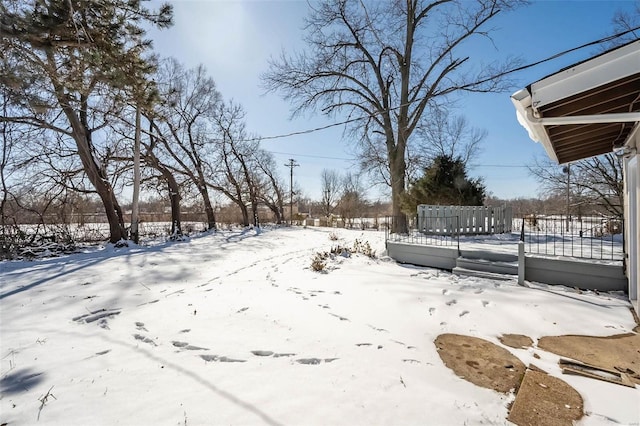 yard layered in snow featuring fence