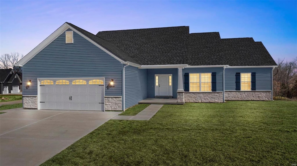 view of front of house with a shingled roof, a garage, stone siding, driveway, and a front lawn