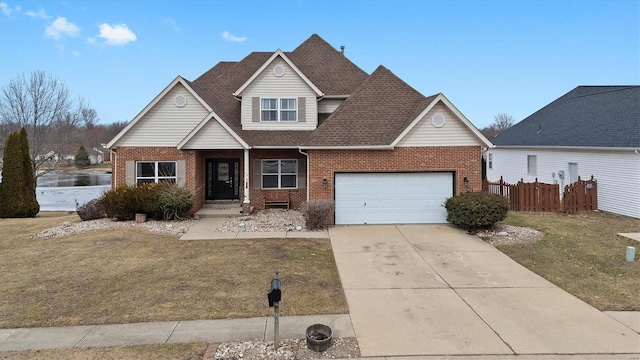 view of front of house featuring driveway, a front yard, fence, and brick siding