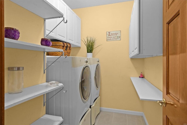 clothes washing area featuring cabinet space, light tile patterned floors, baseboards, and washing machine and clothes dryer