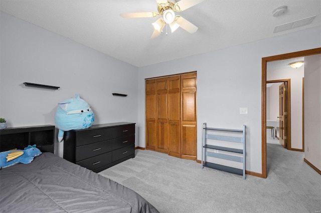 bedroom with ceiling fan, baseboards, a closet, and light colored carpet