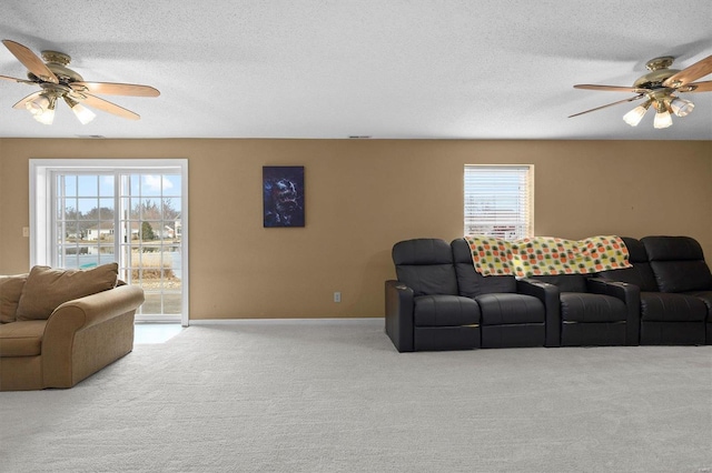 living area featuring a textured ceiling, baseboards, a ceiling fan, and light colored carpet